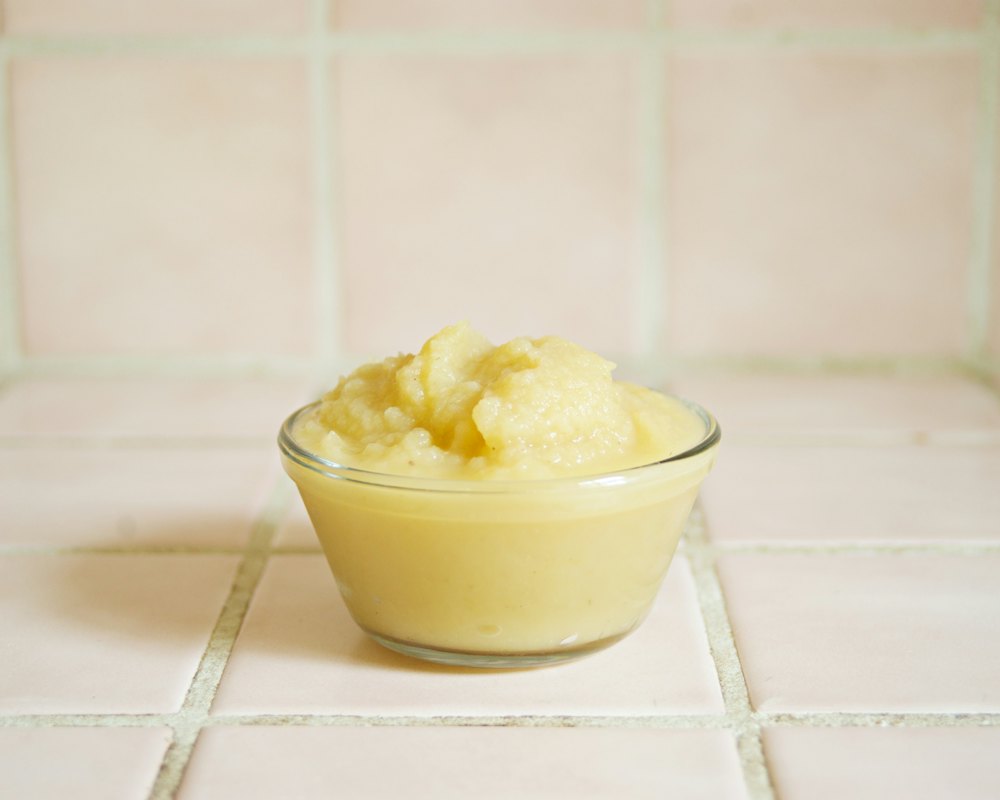 Jar of pink applesauce and a spoon