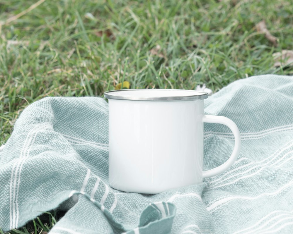Enamel mug steaming on a fence post