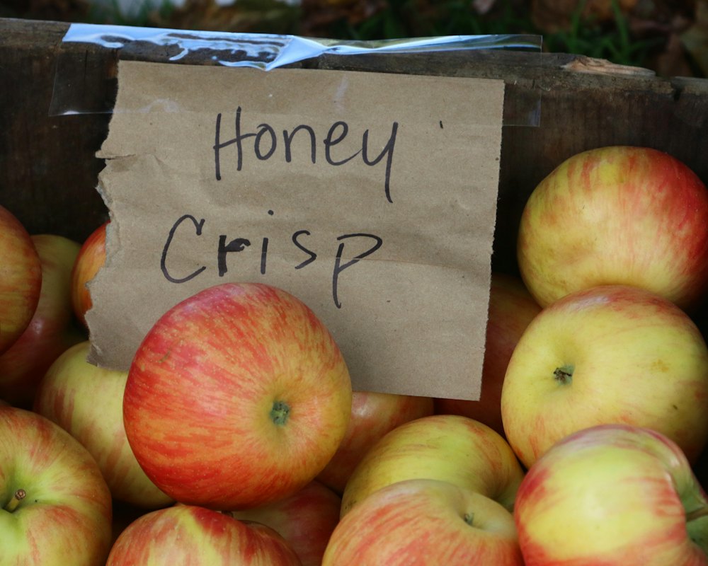 Honeycrisp apples spilling from a paper peck bag onto a crate