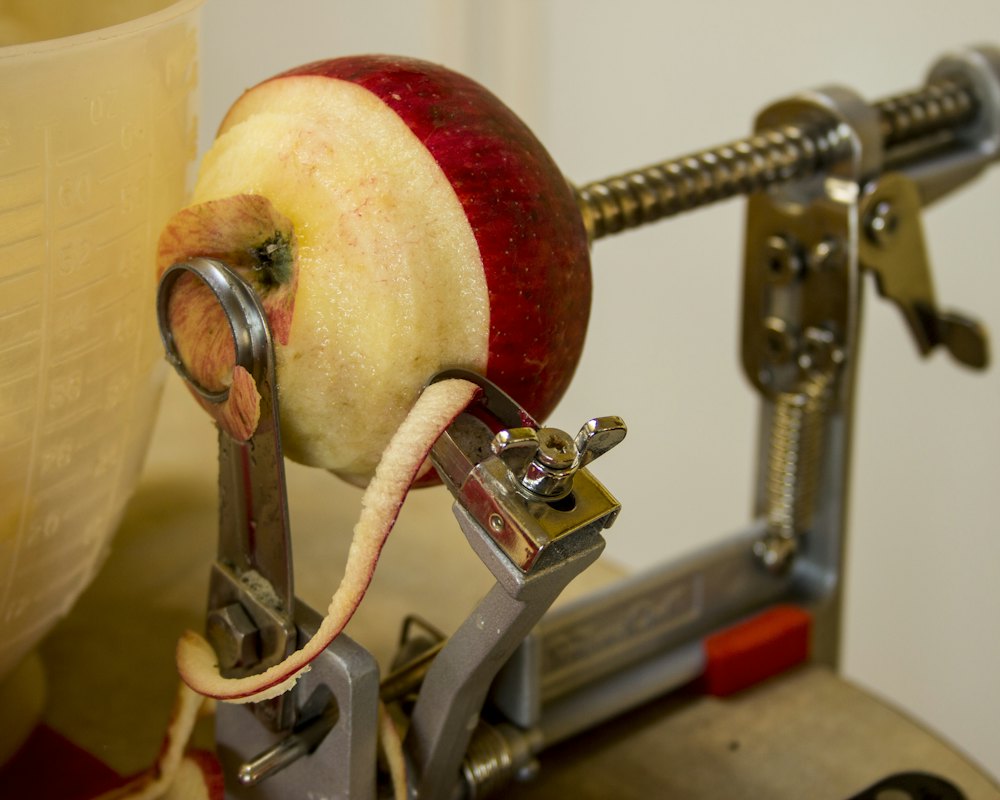 Peeler clamped to a table with apples